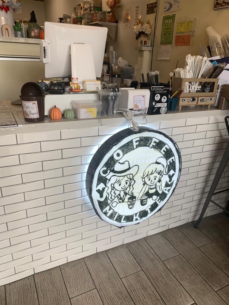 The coffee spot's logo is displayed in the ordering area. The logo is circular in a sketch-like, scrapbook-esque style. "YY Coffee and Milk Tea" is in the circular border, with two women drinking coffee in the inner circle. 